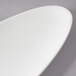 A close up of a 10 Strawberry Street Whittier white porcelain leaf platter with a curved edge.