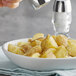 A bowl of potatoes with Regal Table Ground Black Pepper.
