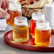 A group of Acopa Rustic Charm mini mason jars filled with beer on a tray.