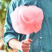 A person holding a pink cotton candy made with Great Western watermelon cotton candy floss.