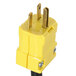 A yellow electrical plug with two gold pins on a black cord.