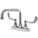 A chrome Advance Tabco deck-mount faucet with wrist handles and extended spout.