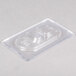 A clear plastic container with a Vollrath 1/9 size plastic lid.