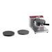A Estella commercial waffle maker with round waffle cone plates on top.