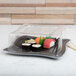 A Fineline plastic container with sushi and a clear dome lid.