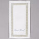 A white paper guest towel with a blue and gold border.