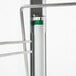 A close up of a metal shelf with a green handle on a white background.