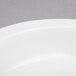 A close-up of a white round ceramic food pan.