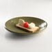A lizard-colored Elite Global Solutions round melamine plate with food on it.