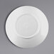 A white plate with a white rim on a gray background.