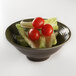 An Elite Global Solutions Lizard-colored melamine bowl filled with a salad with lettuce and tomatoes.