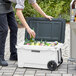 A person holding a CaterGator outdoor cooler full of bottles.