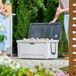 A man and woman standing next to a CaterGator outdoor cooler with the lid open.