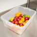 A Vollrath Color-Mate clear plastic bus tub filled with apples, oranges, and lemons.