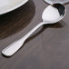 A Oneida Stanford stainless steel bouillon spoon on a table.