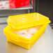 A yellow plastic container with food inside.