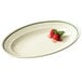 An oval white melamine platter with strawberries on it.