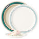 A white melamine plate with a green border with shrimp on it.