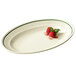 A white oval platter with strawberries and raspberries on it.