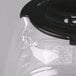 A Proctor Silex glass carafe with a black handle and lid.