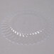 A clear plastic Fineline Flairware plate with scalloped edges.