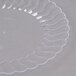 A clear plastic Fineline Flairware plate with wavy edges.