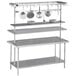An Advance Tabco stainless steel pot rack holding two pots over a table.