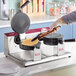A double waffle cone maker with two round cooking plates, one open and one closed, on a stainless steel base.