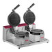 A double waffle maker with two round waffle plates and stainless steel construction.