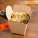 A Fold-Pak Earth 8 oz. paper take-out container filled with food on a table.