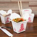 A group of Fold-Pak Chinese take-out boxes with food inside on a table.