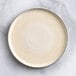 An Acopa Cape white porcelain plate with a thin rim on a marble surface.