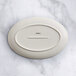 An oval gray porcelain platter with a white oval on it.