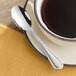 An Acopa Edgeworth demitasse spoon on a saucer with a cup of coffee.