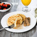 An Arcoroc glass brunch plate with waffles and fruit on it.