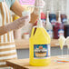 A gallon jug of Carnival King Pina Colada Snow Cone Flavoring Syrup with a pump dispenser.