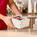 A square bakery box with a modern Christmas tree print and a clear window on top.