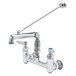 A T&S polished chrome wall mount service sink faucet with a handle and hose.