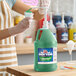 A gallon jug of Carnival King Lemon Lime Snow Cone Flavoring Syrup with a pump dispenser.