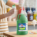 A gallon jug of Carnival King lime snow cone flavoring syrup with a pump dispenser.