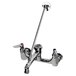 A T&S polished chrome wall mount service sink faucet with two handles and a sprayer.