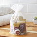 An 11-piece hotel amenity toiletries kit in a sheer drawstring bag, containing various personal care items.