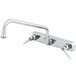 A T&S chrome wall mount faucet with two handles and a swing nozzle.