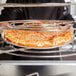 An American Metalcraft pizza pan with a pizza on a metal rack.