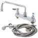 A T&S chrome deck-mount workboard faucet with a hose and spray valve.