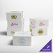 A set of white customizable bakery boxes with various printed logos and designs.