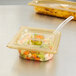 A clear plastic Vollrath high heat slotted cover over a food container.