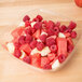 A Sabert clear plastic square bowl filled with watermelon, raspberries, and strawberries.