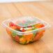 A clear Sabert plastic bowl filled with cut up vegetables.