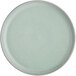 A round, matte, light blue plate with a slightly raised rim.